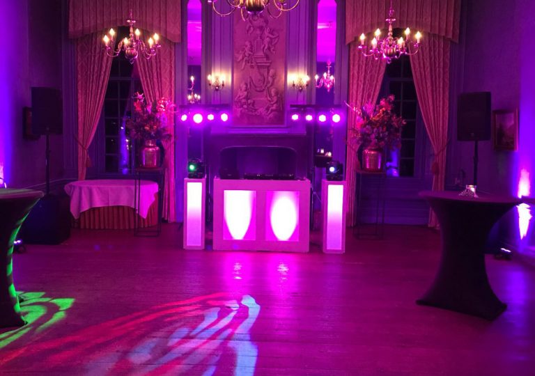 DJ booth met roze verlichting en een lichtpatroon op de dansvloer