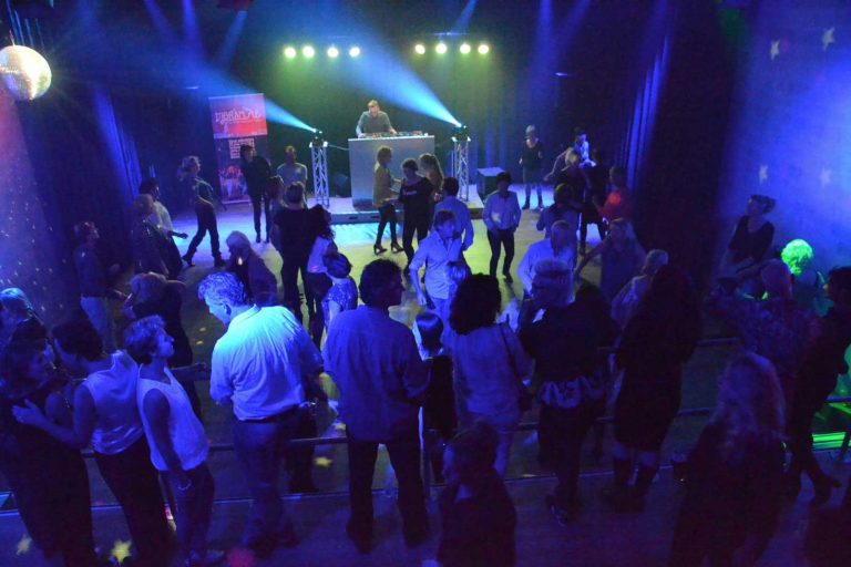 Gasten op een volle dansvloer bij een kerstfeest met DJ